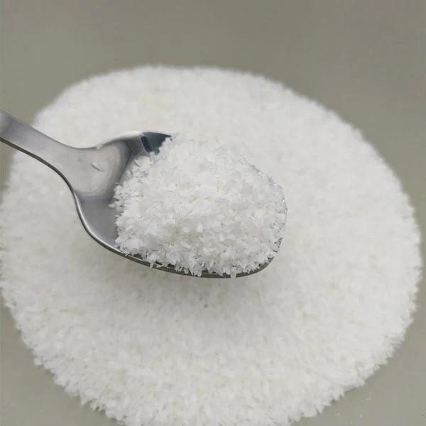 תמונה של כף עם אבקה גבישית לבנה, המונחת על שכבת אבקה דומה ברקע.