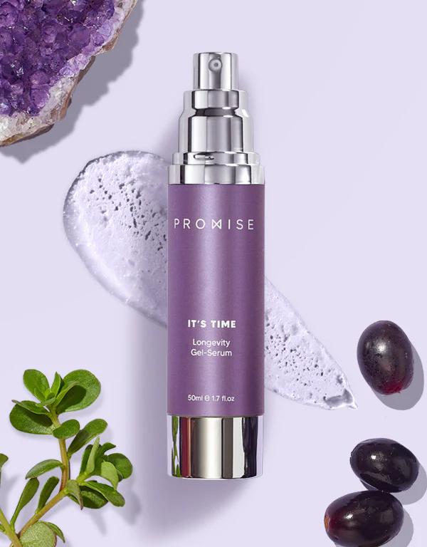 בקבוק סרום בגוון סגול בהיר בשם 'IT'S TIME' עומד על רקע של קצף נוזלי ועלים ירוקים ופירות כהים.