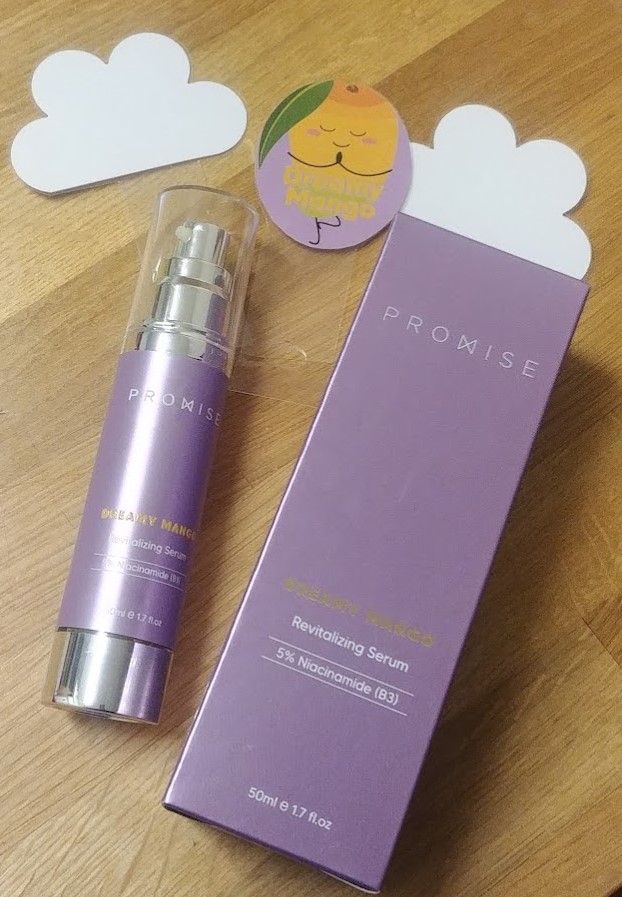 סרום ג'ל בשם Dreamy Mango של פרומיס, בעל ריכוז 5% ניאצינמיד, באריזת משאבה בגוון סגול עם עיצוב מודרני. לידו קופסה תואמת עם פרטים על המוצר.