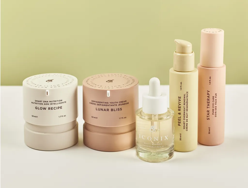 A collection of skincare products from ICONIX, including jars and bottles labeled Glow Recipe, Lunar Bliss, Peel & Revive, and Star Therapy, against a light green background.