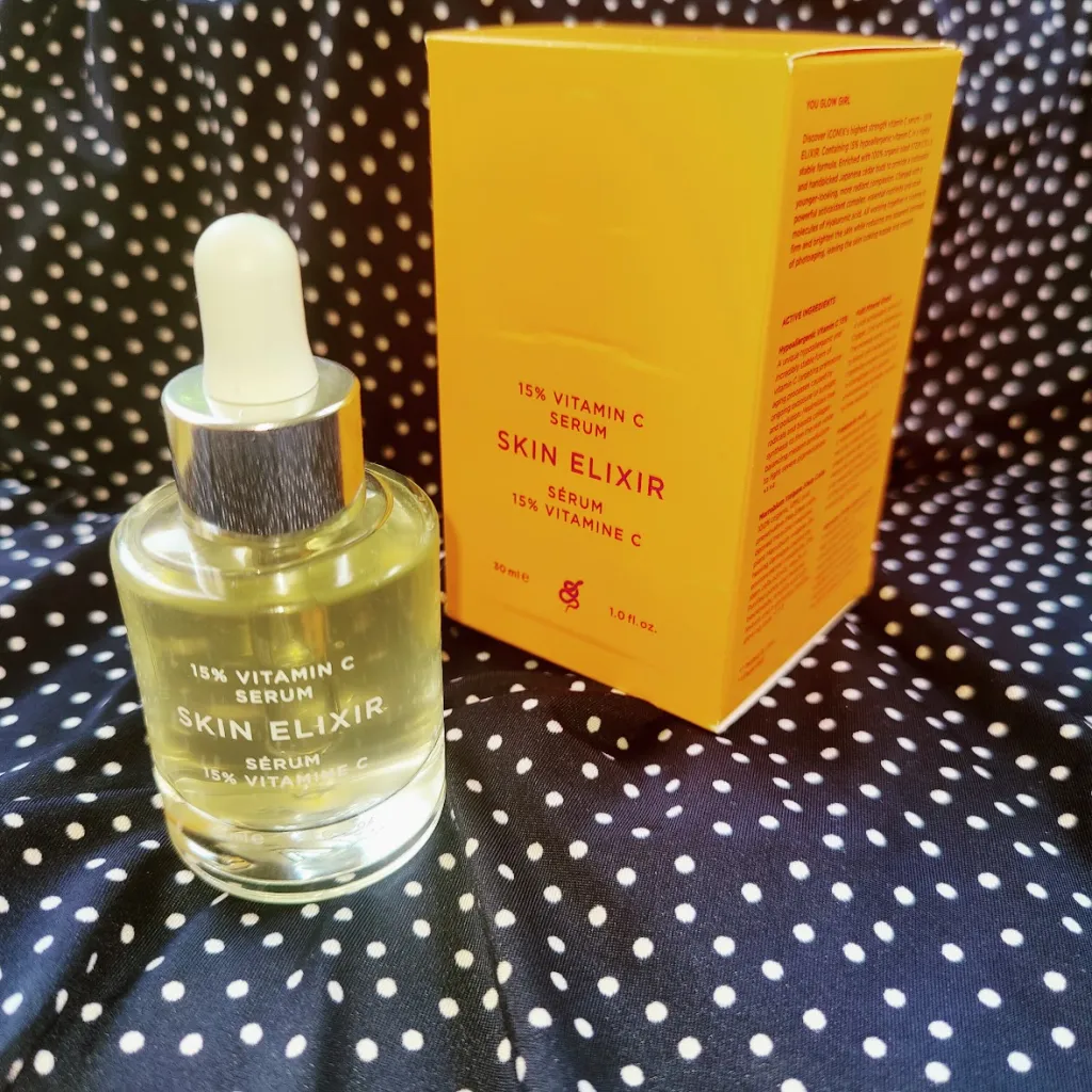 סרום ויטמין C של ICONIX עם תווית צבעונית על רקע בד עם נקודות לבנות.