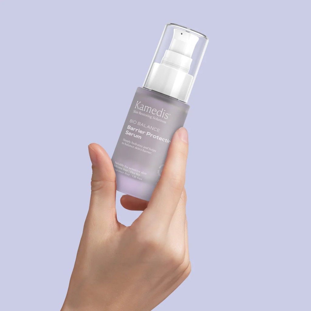 Serum Kamedis Bio Balance Barrier Protecting being held in a hand, featuring a sleek design and a lavender background.